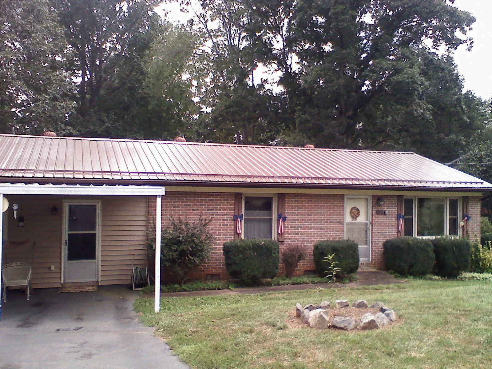 Bronze metal roof and carport on a brick ranch home — Roof Repair work by our crew in Olympia